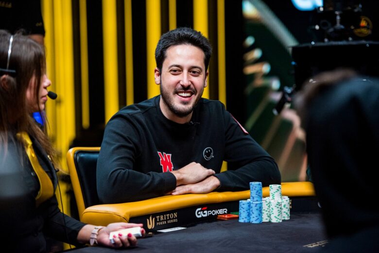 Adrian Mateos, celebrated poker champion, proudly holding a trophy from a major poker tournament.