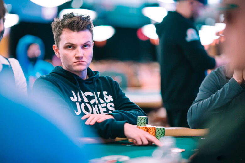 Kulev sits confidently at a poker table, focused on the cards in front of him, reflecting his rise from a passionate enthusiast to a top-tier professional.