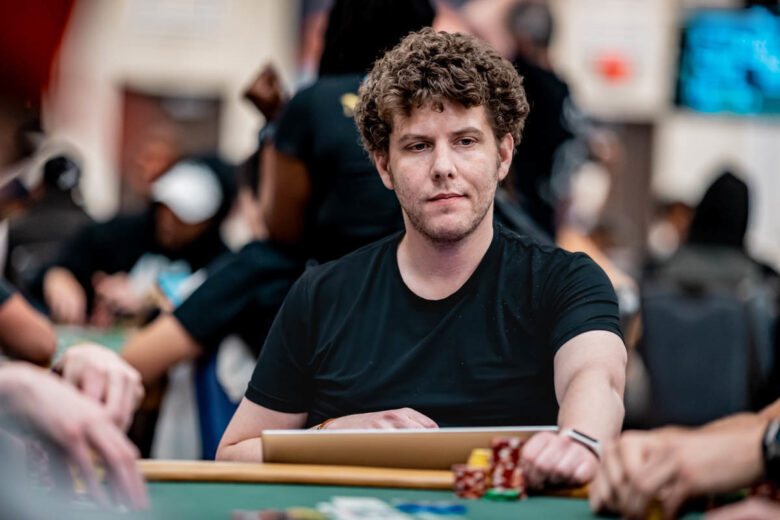 Ari Engel in action at a live poker tournament in Las Vegas, with a crowd of spectators in the background.