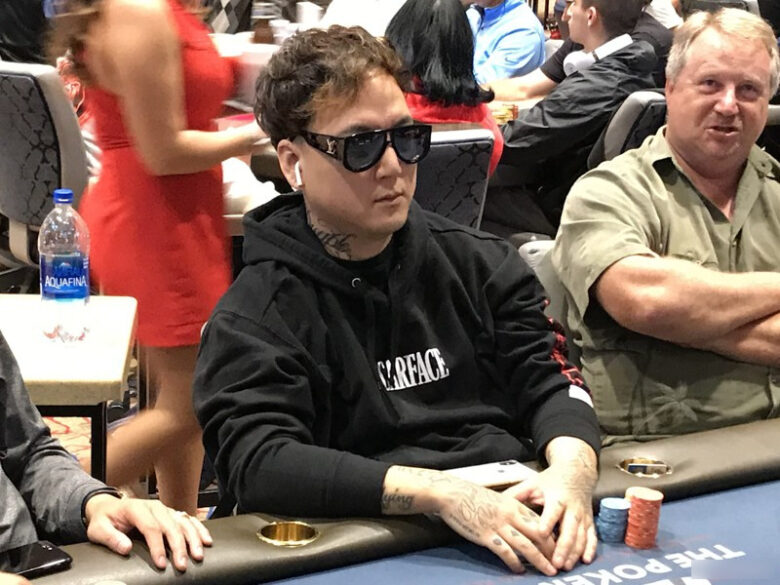 Austin Yoo, a focused poker player at a tournament table, surrounded by fellow competitors.