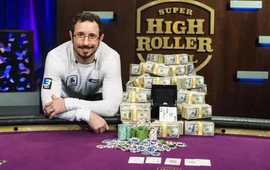 Brian Rast holding one of his five WSOP bracelets, a symbol of his illustrious career.