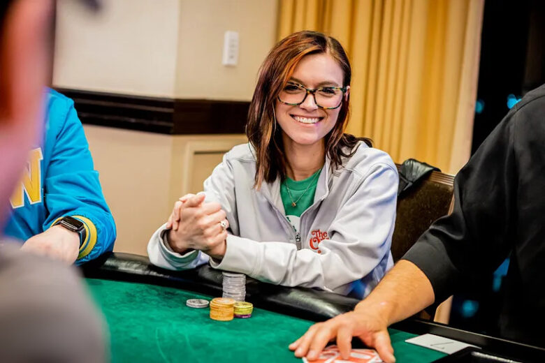 A close-up of Brittney Stout’s hands as she arranges her poker chips, symbolizing her meticulous strategy and sharp skills at the table during an intense game.